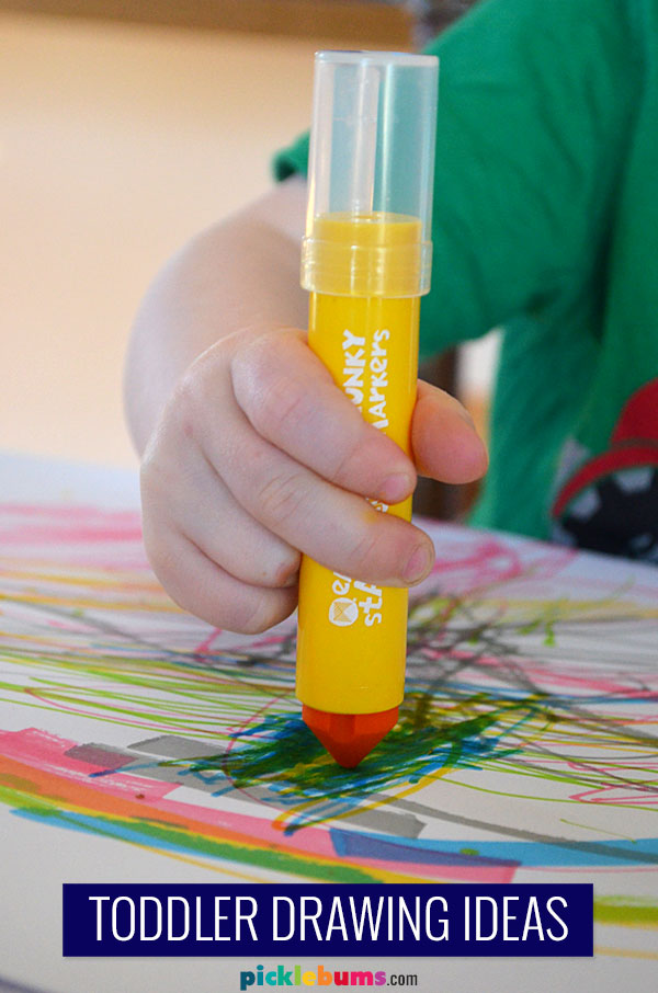 toddler hand scribbling with jumbo marker