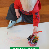 child drawing on big sheet of paper