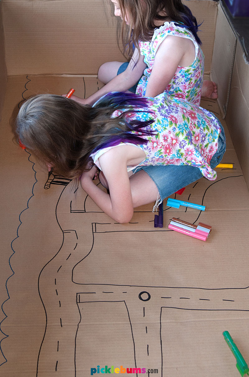 girls drawing on cardboard