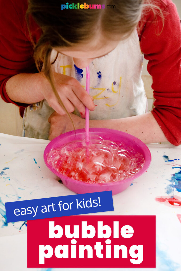 child blowing bubbles with a straw for bubble painting