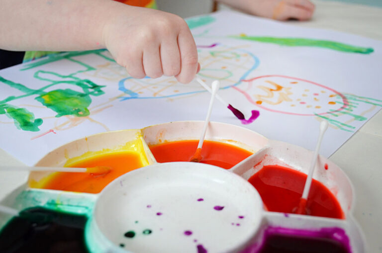 child's hand painting with cotton bud
