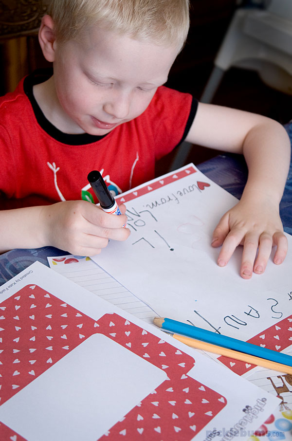 boy in red shirt writing a letter