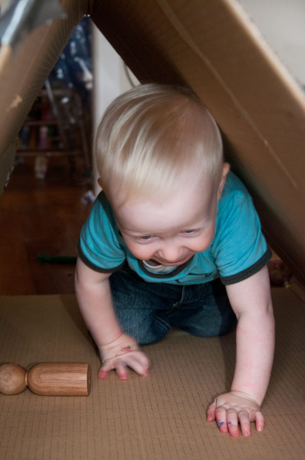 toddler crawling through box tunnel