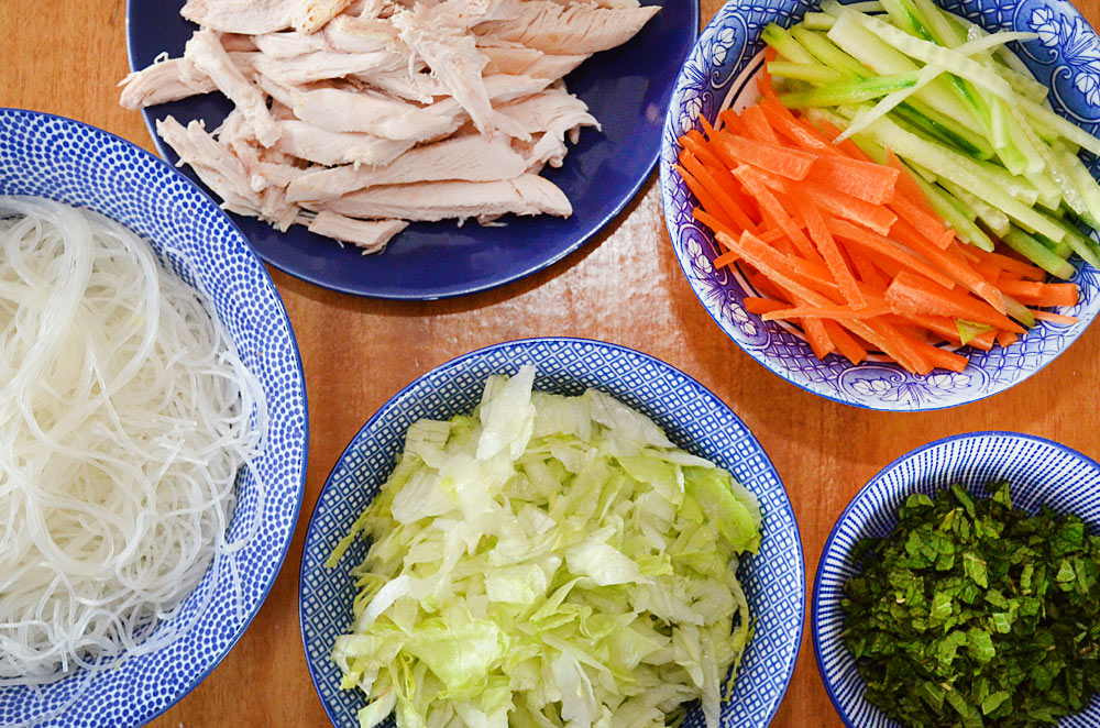 rice paper roll ingredients - rice noodles, chicken, shredded lettuce, mint, carrot and cucumber