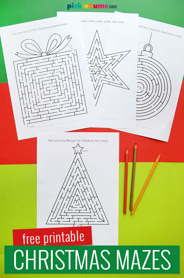 four printed Christmas mazes on a coloured background with pencils