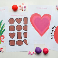 four Valentines' day themed playdough mat printables on white background with playdough and beads