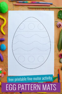Easter egg pattern mat on brown background surrounded by loose parts an pencils
